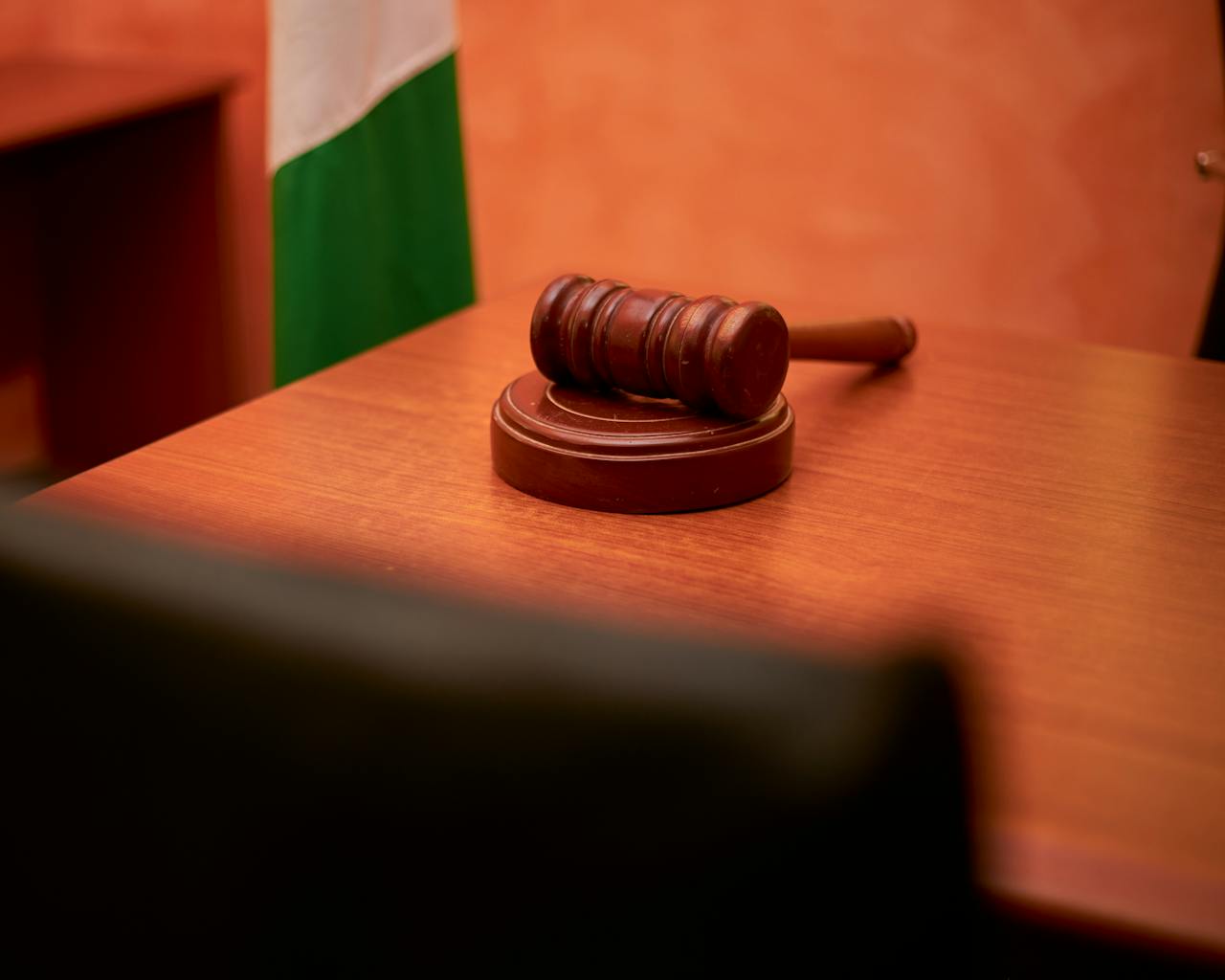 A close-up of a gavel on a courtroom desk representing law and justice.